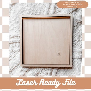 May include: A square, light-colored wooden frame with a brown wooden bar across the top. The text "INTERCHANGEABLE FRAME | INSERTS SOLD SEPARATELY" is in a brown rectangle at the top. The text "Laser Ready File" is in a brown banner at the bottom.
