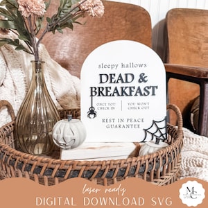 May include: White sign with black text that reads "Sleepy Hallows Dead & Breakfast" with a spider graphic and the text "Once you check in, you won't check out. Rest in peace guarantee."