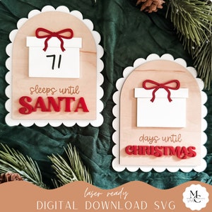 Pode incluir: Dois sinais de madeira com bordas festoneadas, cada um com uma caixa de presente branca com um laço vermelho. O sinal à esquerda diz "71 sleeps until SANTA" e o sinal à direita diz "days until CHRISTMAS".