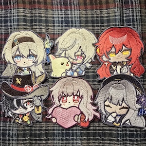 May include: A set of 8 embroidered patches featuring anime characters. The patches are colorful and feature a variety of designs, including a girl with blonde hair, a girl with red hair, a girl with brown hair, a girl with pink hair, a boy with blonde hair, a boy with brown hair, a boy with black hair, and a boy with white hair.