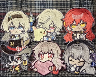 Może przedstawiać: Zestaw 8 haftowanych naszywek z postaciami z anime. Naszywki są kolorowe i przedstawiają różne wzory, w tym dziewczynę z blond włosami, dziewczynę z czerwonymi włosami, dziewczynę z brązowymi włosami, dziewczynę z różowymi włosami, chłopaka z blond włosami, chłopaka z brązowymi włosami, chłopaka z czarnymi włosami i chłopaka z białymi włosami.