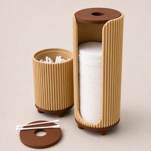 Op de afbeelding: Een beige geribbelde cilindrische wattenschijfjeshouder met een bruine basis en deksel, naast een bijpassende beige geribbelde houder gevuld met witte wattenstaafjes. Een apart bruin rond deksel met een gat in het midden ligt ernaast.
