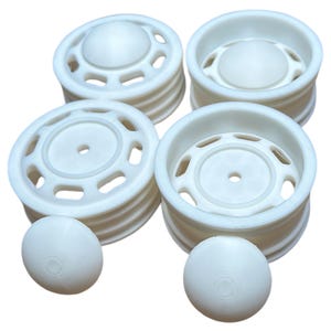 Può includere: Quattro cerchi in plastica bianca con un design decorativo. I cerchi sono impilati a coppie, con due coprimozzi in plastica bianca aggiuntivi.