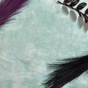 May include: A light blue textured background with two black and purple feather plumes arranged in opposite corners.