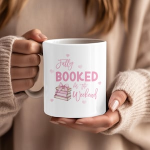 May include: White ceramic mug featuring the pink text "Fully Booked for the Weekend". The design includes a stack of books tied with a pink bow and small pink hearts. A perfect gift for bookworms.