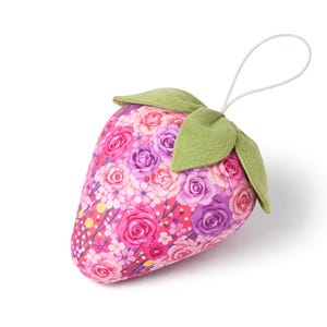 Single pink fabric strawberry ornament with lace bow isolated on white background