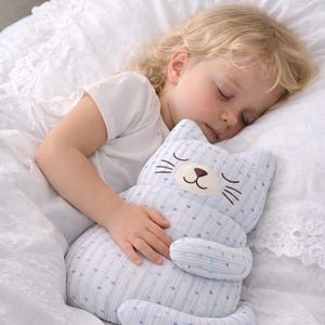 child sleeping with plush cat toy, soft cuddle toy for kids