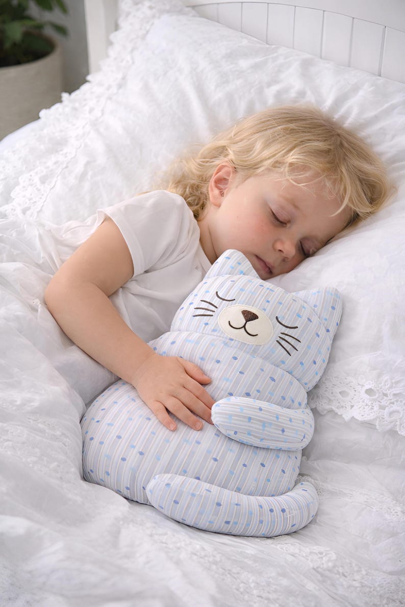 child sleeping with plush cat toy, soft cuddle toy for kids