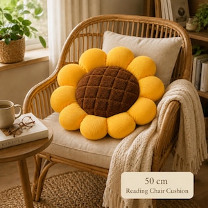 May include: A 50 cm sunflower-shaped cushion with bright yellow corduroy petals and a dark brown textured center. The round pillow features a grid-stitched design on the central portion and is displayed on a wooden chair with a cream-colored throw.
