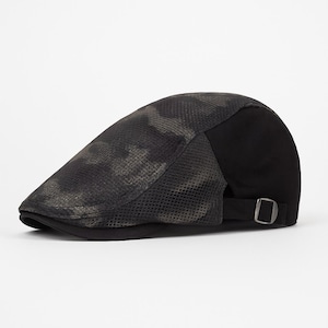 Puede incluir: Gorra plana con un patrón de camuflaje en la parte delantera y una parte trasera negra lisa. La gorra tiene una visera pequeña y una correa ajustable con hebilla metálica. El patrón de camuflaje presenta tonos verdes y marrones.