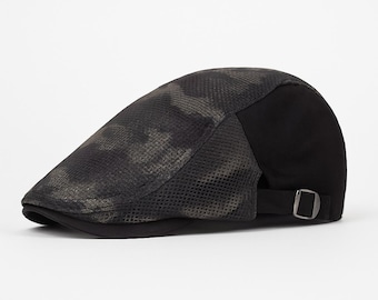 May include: A flat cap with a camouflage pattern on the front and a solid black back. The cap has a small brim and an adjustable strap with a metal buckle. The camouflage pattern features shades of green and brown.