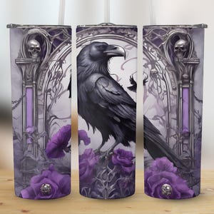 May include: A black raven with purple flowers and a skull design on a white and purple stainless steel tumbler.