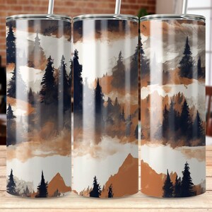 以下が含まれることがあります： 茶色、青、白の色合いの山脈と木々の水彩画のデザインが施されたステンレス製のタンブラー3個