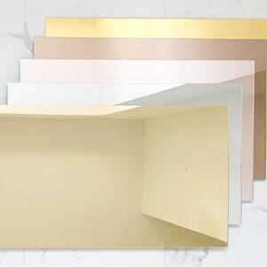 Puede incluir: Un conjunto de seis l&aacute;minas acr&iacute;licas decorativas en varios tonos de oro, rosa y blanco. Las l&aacute;minas est&aacute;n dispuestas de la m&aacute;s oscura a la m&aacute;s clara, con la l&aacute;mina dorada en la parte superior y la l&aacute;mina blanca en la parte inferior.