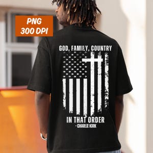 K&ouml;nnte beinhalten: Schwarzes T-Shirt mit einem verblassten amerikanischen Flaggen-Design und einem wei&szlig;en Kreuz. Der Text "GOD, FAMILY, COUNTRY" steht &uuml;ber der Flagge, und "IN THAT ORDER" und "-CHARLIE KIRK" stehen darunter.