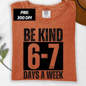 Könnte beinhalten: Ein orangefarbenes T-Shirt mit dem schwarzen Text "BE KIND 6-7 DAYS A WEEK". Das Shirt hat einen Rundhalsausschnitt und ist aus einem weichen Material. Das Bild enthält auch ein PNG-Logo mit 300 DPI.