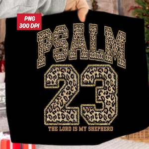 May include: Black t-shirt with the text "PSALM 23" in a leopard print design with gold glitter trim. The text "THE LORD IS MY SHEPHERD" is at the bottom. The image also includes a "PNG 300 DPI" label.