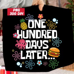 May include: Black t-shirt with the text "ONE HUNDRED DAYS LATER..." in white. The design includes a yellow pineapple, a pink octopus, a hamburger, and various cartoon flowers and bubbles.