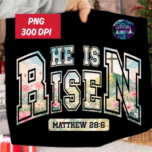 Könnte beinhalten: Schwarzes T-Shirt mit dem Schriftzug "HE IS RISEN" in einer College-Schriftart, gefüllt mit einem Blumen- und Landschaftsdesign. Der Text "MATTHÄUS 28:6" steht darunter. Ein rotes Quadrat mit "PNG 300 DPI" befindet sich oben links.