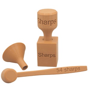 May include: A set of tan-colored 3D-printed medical tools, including a funnel, a scoop, and a container with the word "Sharps" printed on it. The scoop has the text "54 sharps".