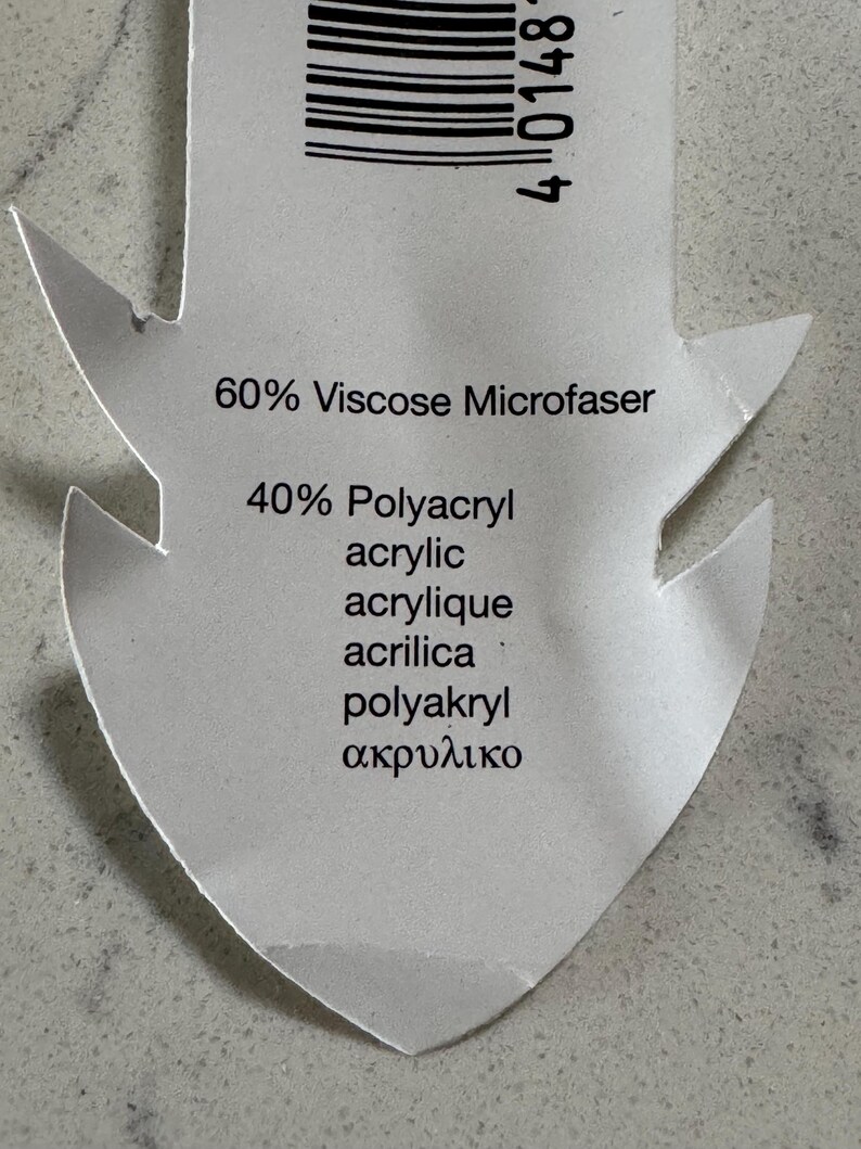 Puede incluir: Una etiqueta de tela blanca con texto negro que indica la composici&oacute;n de la tela: 60% Viscosa Microfaser, 40% Poliacr&iacute;lico Acr&iacute;lico Acr&iacute;lico Acrilica Poliakryl &alpha;&kappa;&rho;&upsilon;&lambda;&iota;&kappa;ό