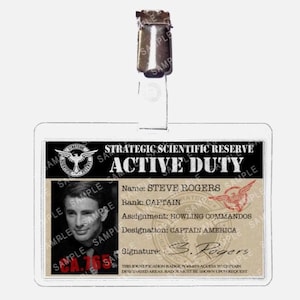 May include: A clear plastic ID badge with a metal clip at the top. The badge features a photo of a man and text that reads "STRATEGIC SCIENTIFIC RESERVE ACTIVE DUTY" and "CAPTAIN AMERICA".