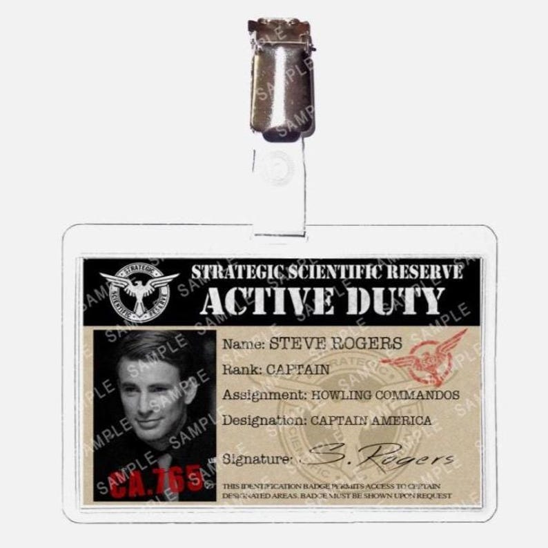 May include: A clear plastic ID badge with a metal clip at the top. The badge features a photo of a man and text that reads "STRATEGIC SCIENTIFIC RESERVE ACTIVE DUTY" and "CAPTAIN AMERICA".