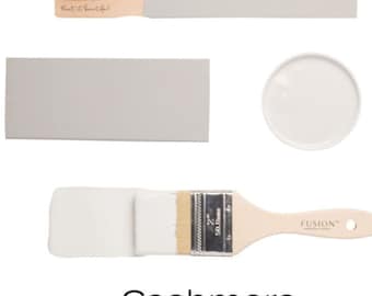 May include: A paint sample of Fusion Mineral Paint in the color Cashmere. The sample is shown on a wooden stick, a paint chip, and a paint brush. The paint is a light gray color.