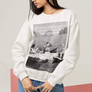 Może przedstawiać: Biała bluza z nadrukiem w czerni i bieli przedstawiającym ludzi na tratwie, z napisem "Everything you see, I owe to spaghetti." Bluza wykonana jest z miękkiego materiału.