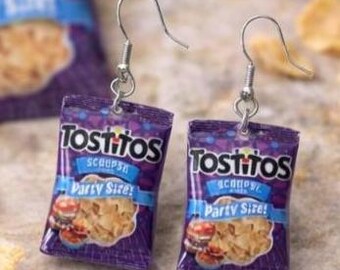 May include: A pair of dangle earrings featuring miniature purple Tostitos Scoops Party Size tortilla chip bags. Each earring has a silver-toned metal hook and a small jump ring connecting the miniature bag charm to the ear wire.