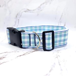 Peut inclure: Un collier pour chien avec un motif vichy bleu et blanc. Le collier est équipé d'une boucle en plastique noir et d'un anneau en D en métal argenté pour attacher la laisse. Fabriqué en tissu, il est conçu pour les animaux de compagnie.