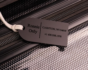 May include: Black luggage tag with the text "Ronnie Only" and contact information: CASHTON, WI 54619 +1 430.558.1376