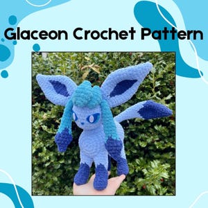 Könnte beinhalten: Gehäkeltes Glaceon-Plüschtier in verschiedenen Blautönen mit großen Ohren und dunkelblauen Akzenten. Der Text "Glaceon Crochet Pattern" ist oben im Bild zu sehen.