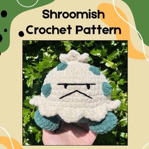 Pode incluir: Um brinquedo de pelúcia em forma de cogumelo de crochê com uma cara rabugenta, corpo branco e detalhes em verde-azulado. O texto "Shroomish Crochet Pattern" está no topo da imagem. O fundo é uma mistura de verde e bege.