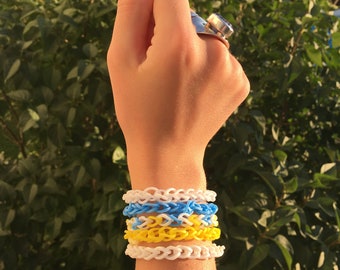 Juego de pulseras de goma azul, amarilla y blanca.