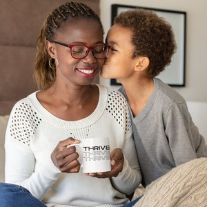 Taza de café con letras apiladas Thrive