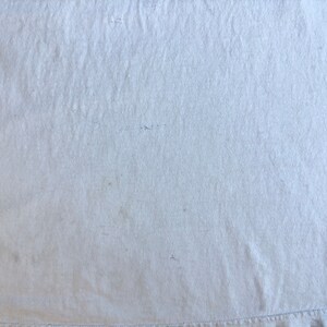 Pode incluir: Uma superf&iacute;cie de tecido branco lisa com uma textura sutil. O tecido tem um brilho leve e parece suave e liso.