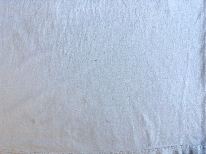 Pode incluir: Uma superf&iacute;cie de tecido branco lisa com uma textura sutil. O tecido tem um brilho leve e parece suave e liso.