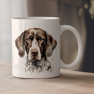 May include: White ceramic mug featuring a watercolour illustration of a brown and white German Shorthaired Pointer dog. The dog is looking directly at the viewer.
