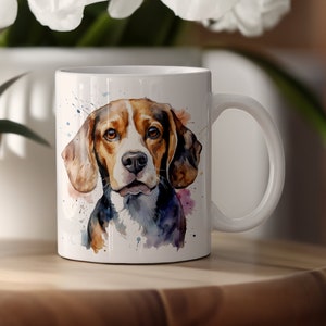 Könnte beinhalten: Weiße Keramiktasse mit einer Aquarell-Illustration eines Beagle-Hundes. Der Hund hat braunes, schwarzes und weißes Fell und schaut direkt auf den Betrachter. Der Hintergrund ist hellblau mit Spritzern von Rosa und Gelb.