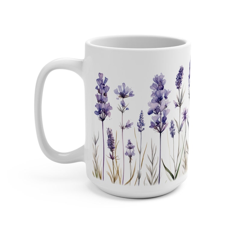 May include: White ceramic mug featuring a watercolor design of lavender flowers in shades of purple and green. The mug has a large handle and a wide base. The lavender design is printed on the front of the mug.