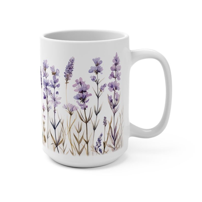 May include: White ceramic mug featuring a watercolor design of lavender flowers in shades of purple and green. The mug has a large handle and a wide base, perfect for coffee or tea. The floral design wraps around the mug.