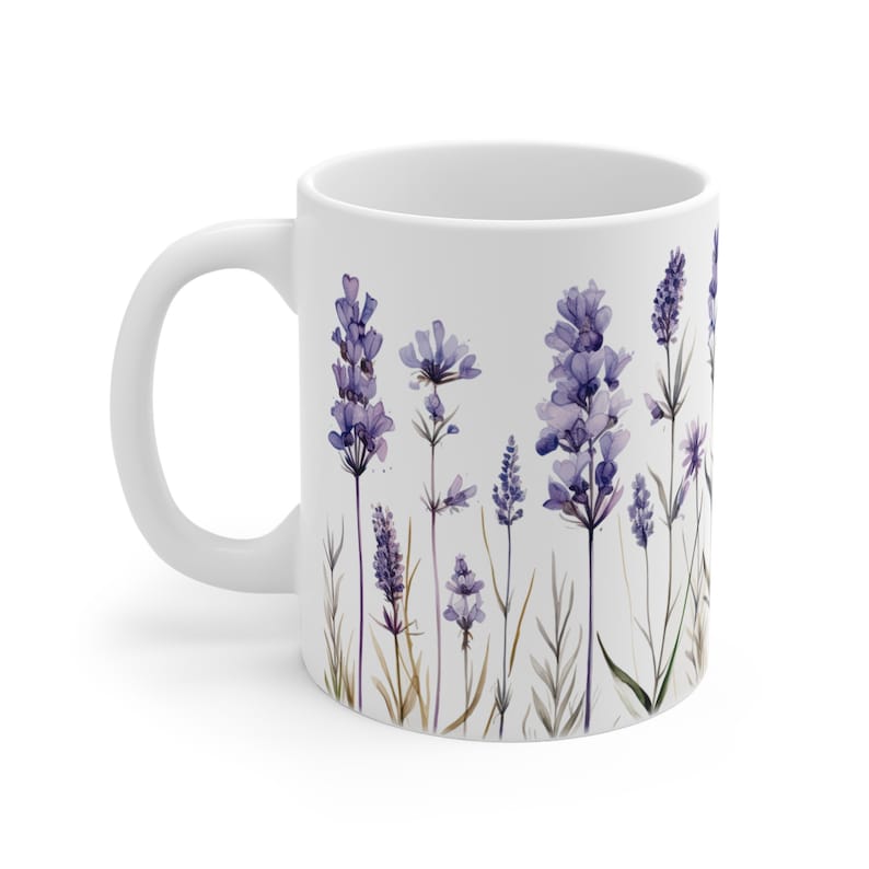 May include: White ceramic mug featuring a watercolor design of lavender sprigs in shades of purple and green. The floral pattern is arranged against a white background. The mug has a curved handle.