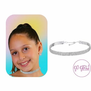 May include: A silver choker necklace with multiple rows of sparkling rhinestones. The necklace is on a white background.