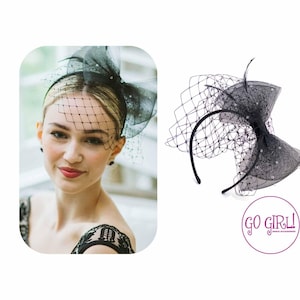 May include: Black headband with a large black bow and a black tulle veil. The bow is decorated with small black sequins. The headband is made of a flexible material and is designed to fit comfortably on the head.  "GO GIRL!" is printed on a pink circle in the lower right corner of the image.