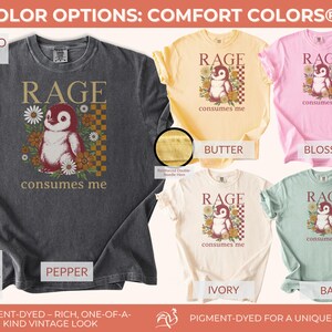 May include: Comfort Colors 1717 t-shirts in colours such as pepper, butter, blossom, ivory, and bay. Each shirt displays a penguin graphic with the text "Rage consumes me". The shirts are garment-dyed for a vintage appearance.
