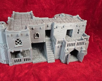 Könnte beinhalten: Ein graues Miniatur-Burgmodell mit einem Turm, gewölbten Türen und einer Treppe. Das Modell hat eine strukturierte Oberfläche und befindet sich vor einem roten Hintergrund. Die Burg hat ein detailliertes Dach und Balkone.