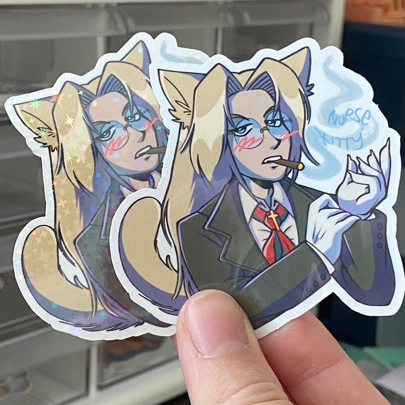 Puede incluir: Dos pegatinas con un personaje de dibujos animados con cabello largo y rubio, orejas de gato y gafas. El personaje lleva un traje negro, corbata roja y guantes blancos. El personaje fuma un cigarrillo y el texto "nurse kitty" es visible en la pegatina.