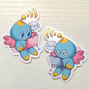 May include: Two stickers featuring a blue cartoon character with yellow accents, pink wings, and a laptop. The character has a speech bubble with text and is surrounded by wireless signal lines. The text "Nurse Kitty" is written on the sticker.