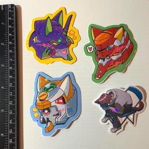 May include: Four colorful stickers featuring anime characters. The stickers are printed on a white background with a holographic finish. The characters are a green and purple cat-like robot, a red and orange robot with a heart, a white and yellow robot with a large eye, and a purple-haired character sitting on a chair.